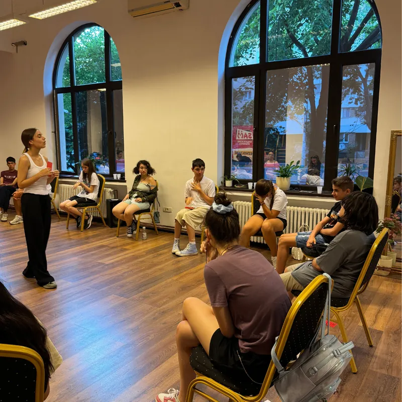 Copii și traineră, așezați în cerc, la începutul ședinței Copii și traineră, așezați în cerc, la începutul ședinței