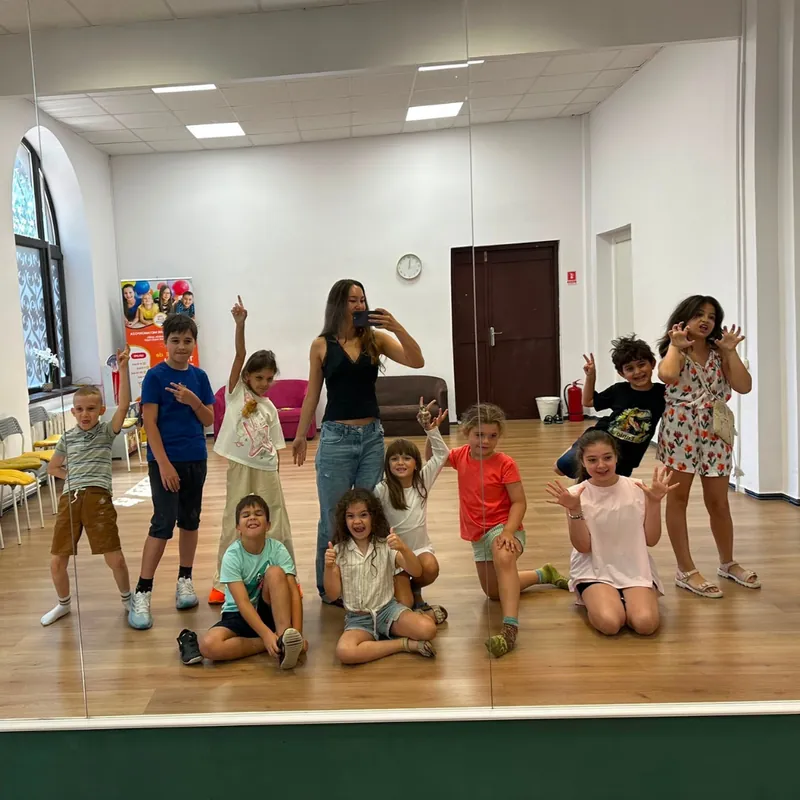 Copii mici la un joc de mișcare, în sala de curs de la SAM Copii mici la un joc de mișcare, în sala de curs de la SAM